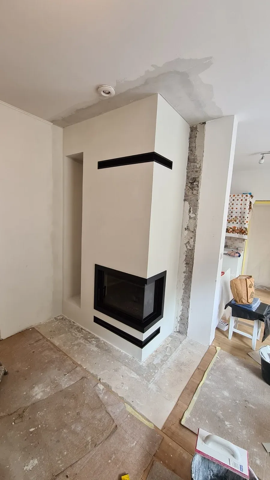Zděný bílý krb s panoramatickou krbovou vložkou
